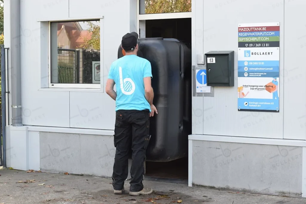 Compacte vetput horeca. Een technicus manoeuvreert een compacte, bovengrondse vetafscheider door een smalle deuropening. Dit toont hoe de vetput makkelijk geïnstalleerd kan worden in technische ruimtes of kelders.